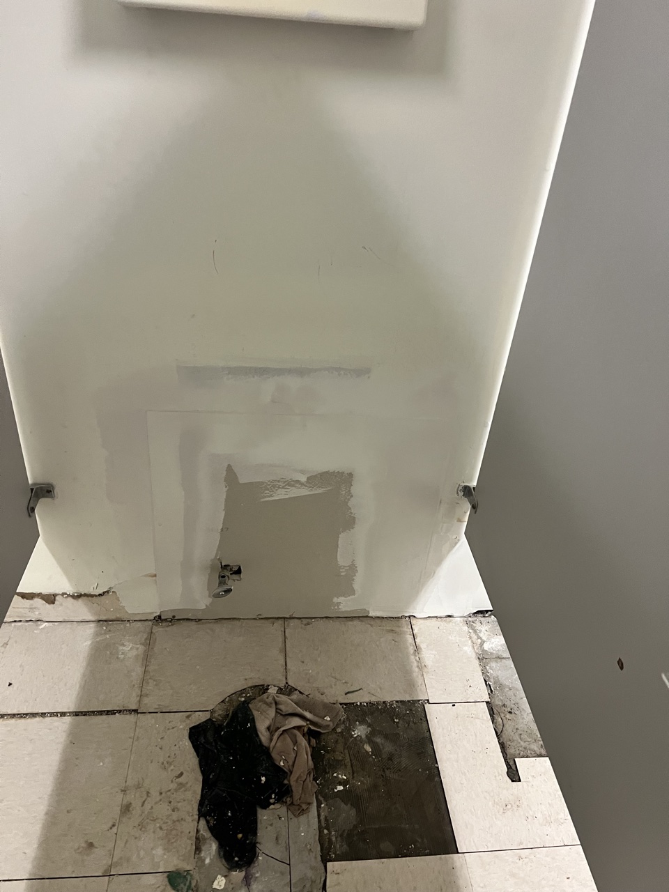 Drywall patch in progress on a restroom wall