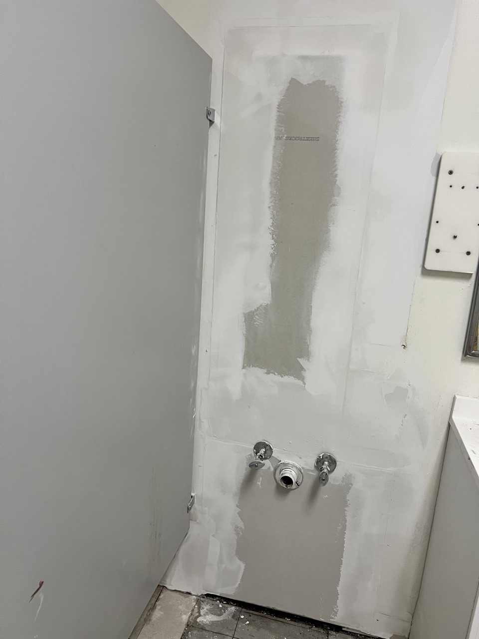 Drywall mud applied around plumbing stub-outs
