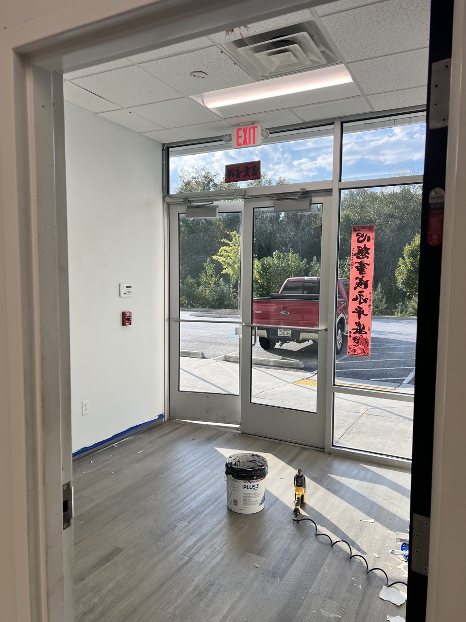 Glass lobby entrance doors of the JW Fulfillment facility after wall repair and painting